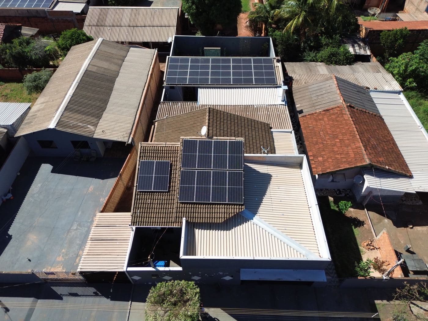 Vista aérea de quadra urbana com vários telhados com painéis solares
